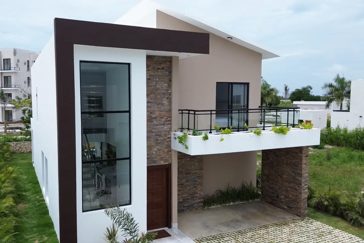 Fachada de Nain Luxury, con ventanal vertical, balcón y jardín frontal.